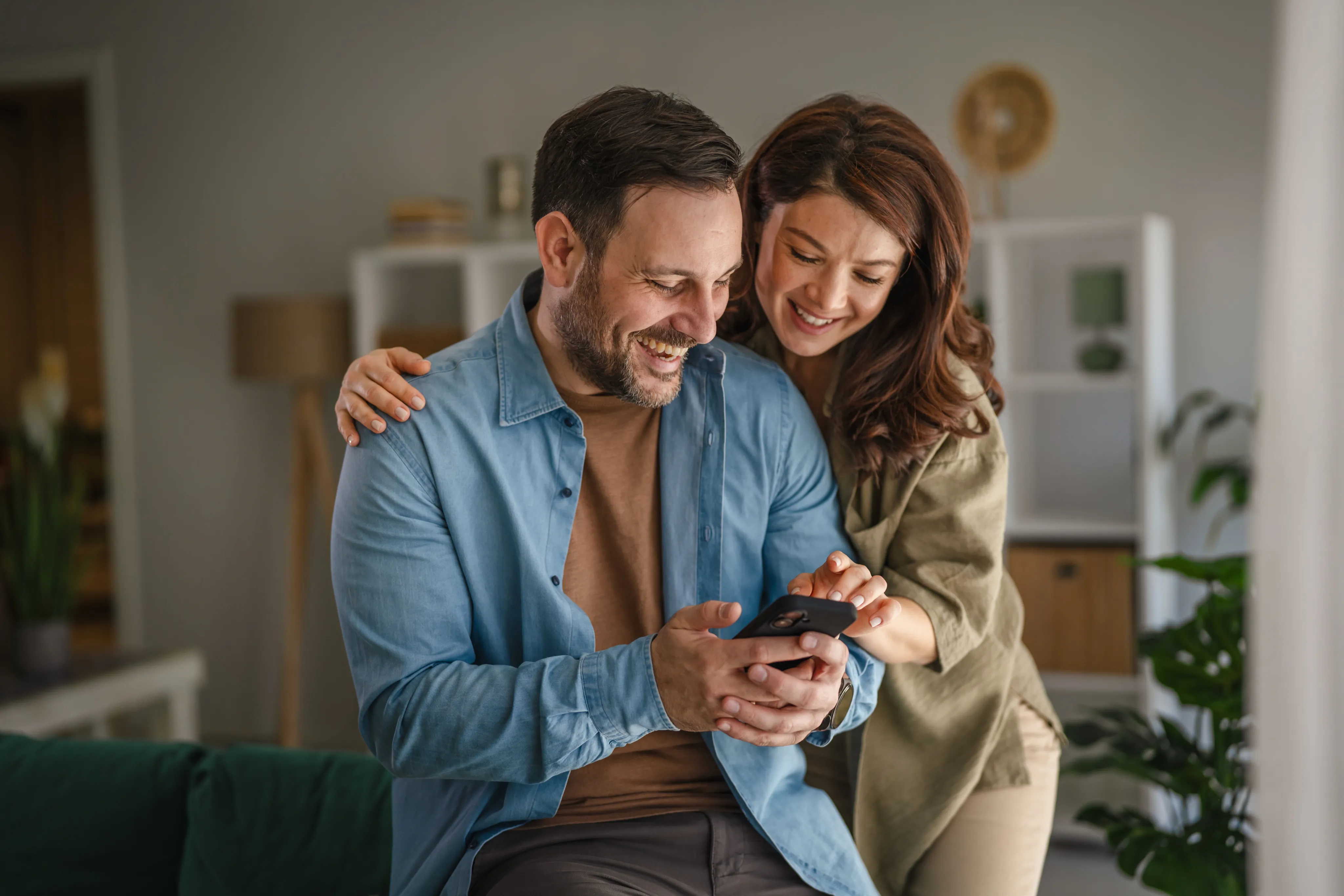 Uśmiechnięta para wspólnie sprawdza telefon